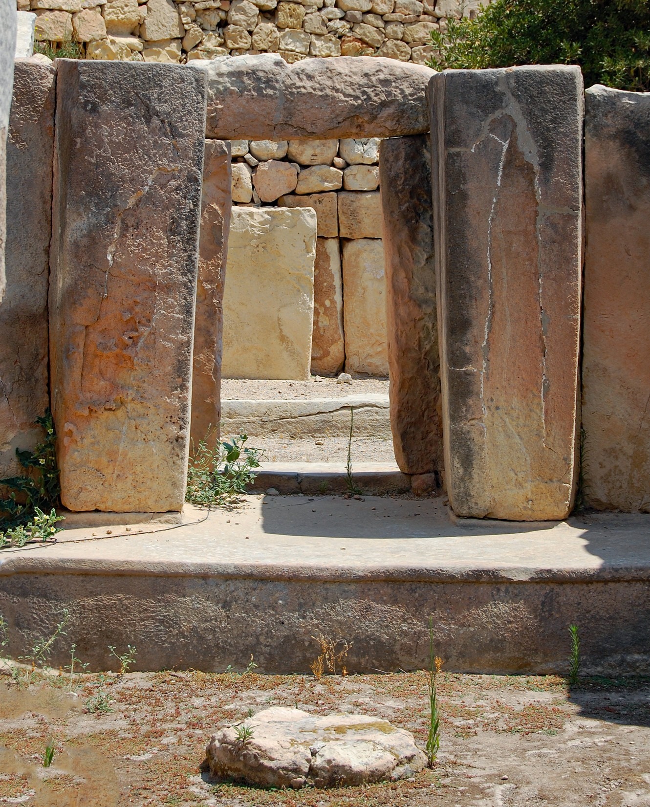This image shows well-cut stone slabs arranged as a portal within the Ħal Tarxien Prehistoric Complex.